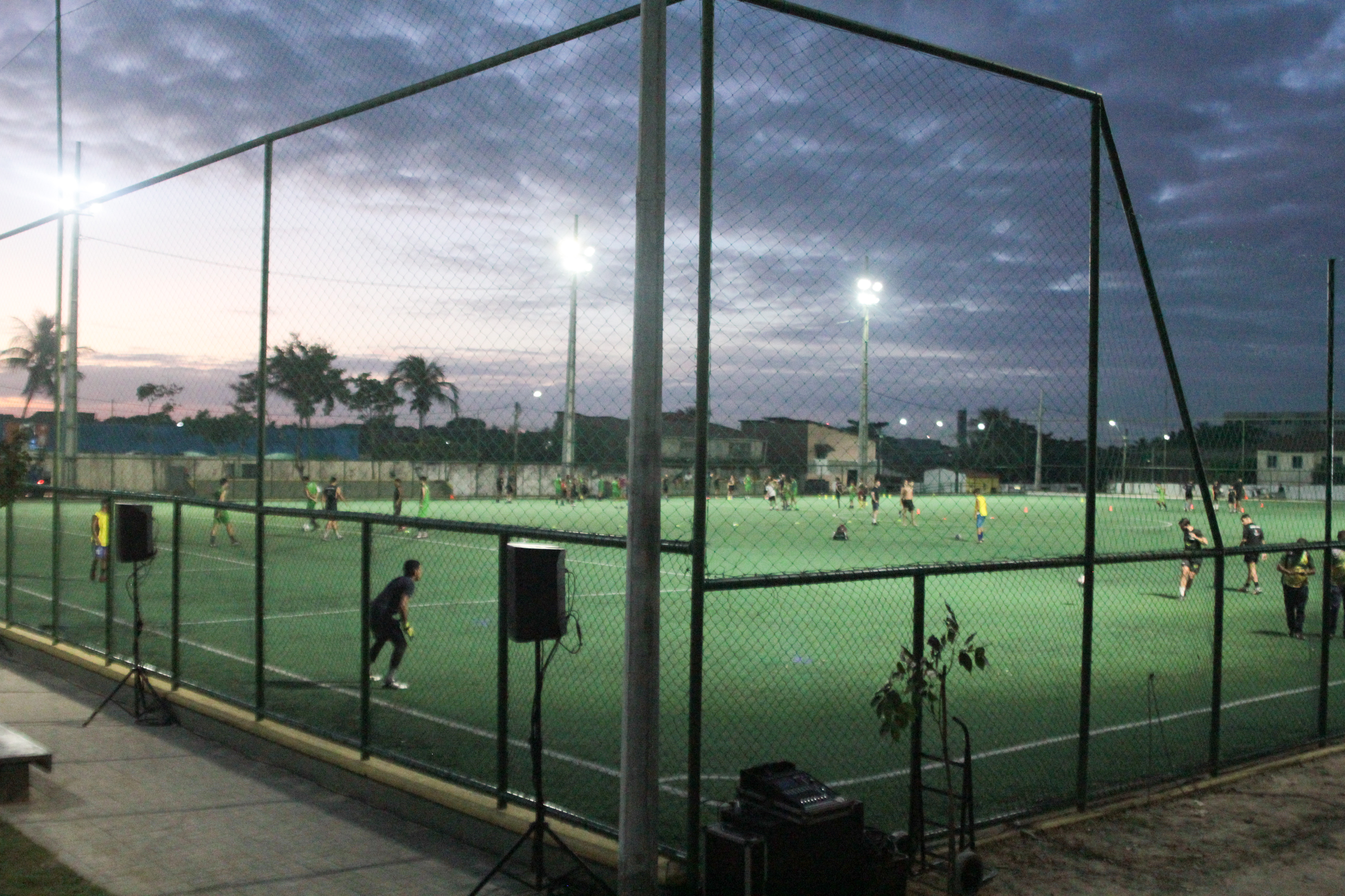 imagem aberta de uma areninha mostrando pessoas jogando futebol